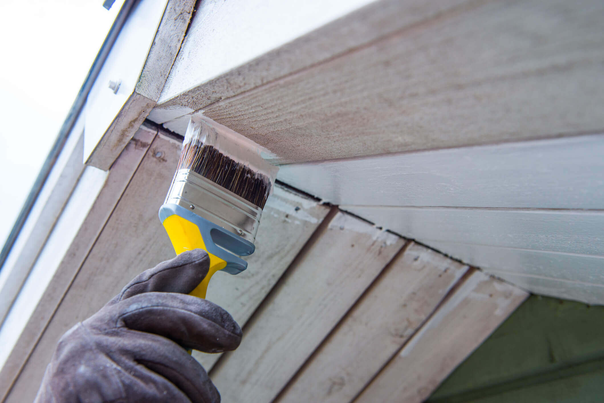 exterior trim on a home being painted with a paintbrush
